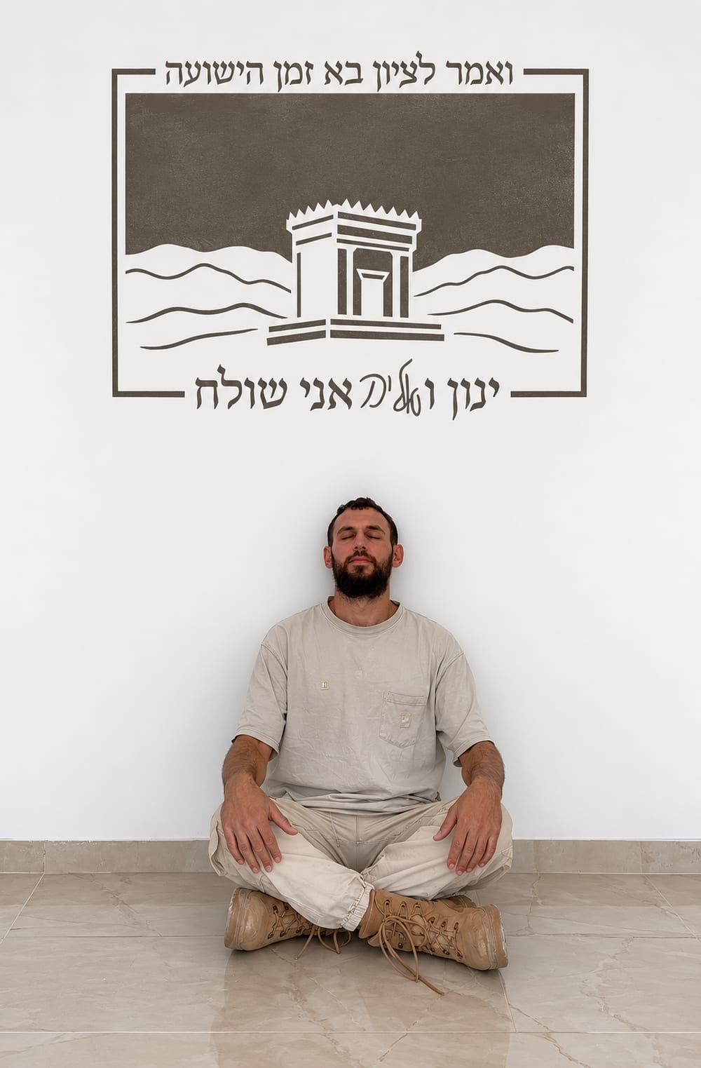 אחיטוב ששון ממן, מייסד ותחזינה, יושב מתחת ליצירת קיר חצובה